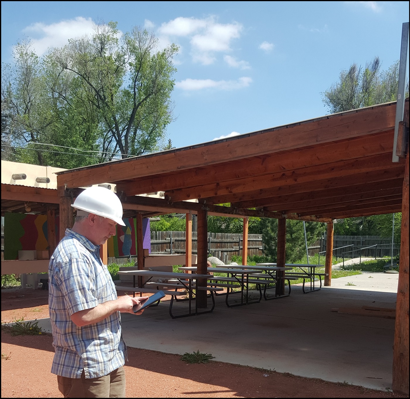 Here, the photograph shows Michael Menand using a tablet to collect location data.