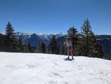 Drew Derderian on El Capitan with Half Dome behind him.